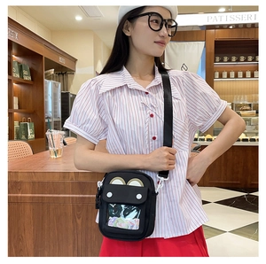Japanese style cute black crossbody bag with clear window shown in a cafe setting