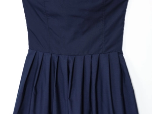 Gros plan détaillé sur la taille plissée d'une robe bustier en popeline bleu marine