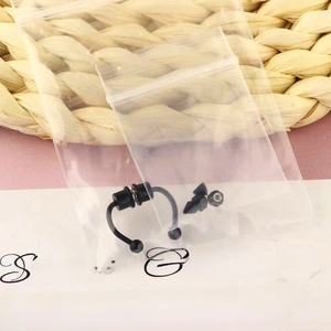 Detail of a black magnetic horseshoe fake nose ring with triangle charm in packaging