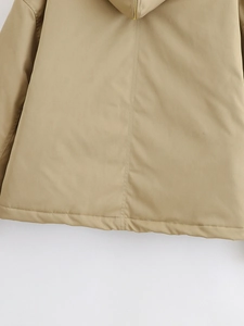 Close-up of the khaki parka back seam details and golden metal zipper hardware