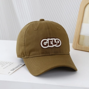 Close-up of khaki cotton baseball cap featuring GELD embroidered patch and premium twill texture