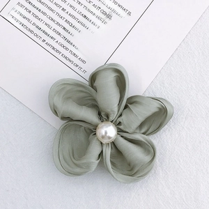 Detailed view of handmade dusty green fabric flower with a central pearl bead embellishment