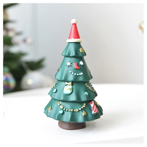 Detail of cute green resin Christmas tree ornament with red hat and smiling face