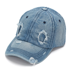 Detail of washed denim baseball cap featuring vintage distressed holes and stitching