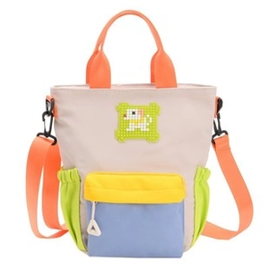 Detail of colorful patchwork denim tote bag with pixel puppy patch and orange strap