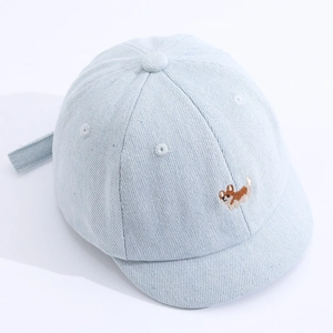 Détail de la casquette bébé en denim bleu clair avec une broderie de chiot corgi mignon