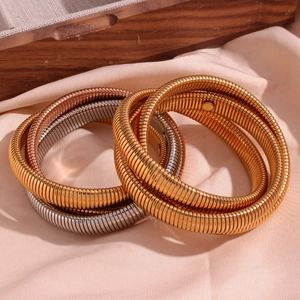 Detailed view of triple-layered flexible snake chain bracelets in gold and silver finish