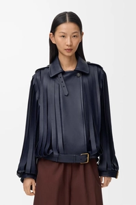 Detail of navy blue leather jacket featuring fringe decor and a belted hem with metal buckle