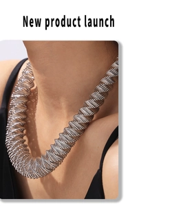 Detail of silver spring-shaped necklace with unique spiral design on model's neck