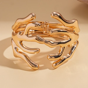 Detail of gold organic liquid metal bracelet with hinge and polished mirror finish