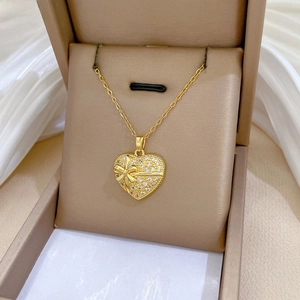 Détail d'un collier cœur doré avec strass présenté dans son écrin à bijoux de luxe