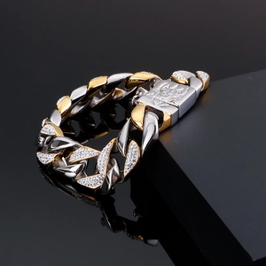 Close-up of gold and silver cuban link bracelet with zircons and dragon head clasp