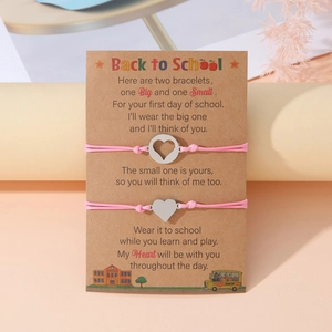Braccialetti in corda rosa con ciondoli a cuore su biglietto Back to School per madre e figlia