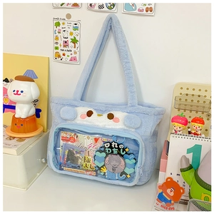 Detail of light blue plush tote bag with a clear window for displaying anime pins