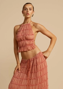 Detailed texture of coral pink pleated chiffon fabric on halter top and maxi skirt set