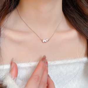 Close-up of a rose gold necklace with a cute dog pendant worn on a model neck