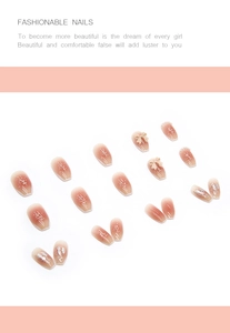Detail of nude pink gradient press-on nails with 3D bows, pearls and aurora glitter