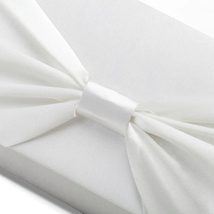 Close-up detail of white satin bow texture with elegant folds and silky finish on the bag