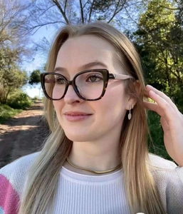 Fashionable tortoise shell cat eye glasses frame worn by a model in outdoor lighting