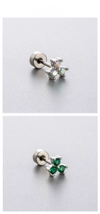 Detailed macro view of three-leaf clover stud earrings with opal and emerald stones