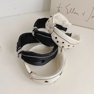 Detail of knotted silk headbands with polka dots and sparkling rhinestone rings