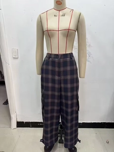 Close-up of plaid cargo pants featuring large utility pockets and adjustable cinched cuffs