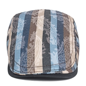 Detail of vintage paisley pattern and vertical stripes on retro flat cap with black brim