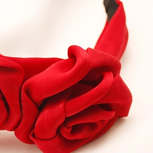 Detailed view of red fabric rose headband with satin texture and handmade floral folds