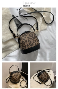 Detail of leopard print cylinder bag with black leather base and gold metal hardware