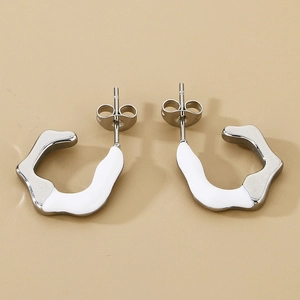 Detail of C-shape geometric stainless steel earrings with white enamel and silver finish