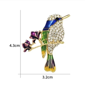 Detail view of the colorful enamel hummingbird brooch with dimensions 4.3cm by 3.2cm
