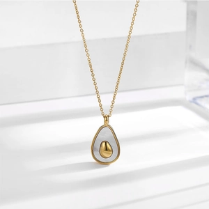 Gros plan du pendentif avocat avec nacre blanche sur collier en titane doré 18 carats