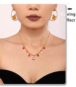 Wearing effect of golden Christmas tree necklace and hoop earrings with enamel details