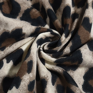 Nahaufnahme von Strickstoff mit Leopardenmuster zeigt Textur und Faserstruktur im Detail