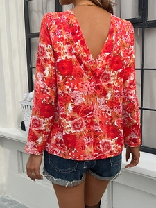 Detail of red long-sleeved top featuring a V-shaped open back and rose floral prints