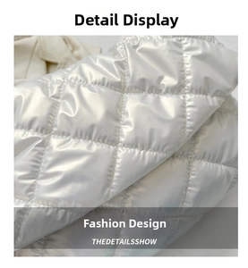 Detail view of the white shoulder bag featuring classic diamond quilted glossy fabric