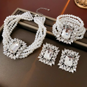 Luxe layered pearl necklace and bracelet set with square zircon accents on wood background