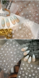 Detail of snowflake and butterfly nail stickers with gold accents and winter patterns