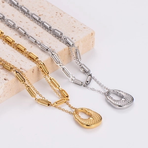 Golden and silver hollow horseshoe necklaces with grid texture on stone display blocks
