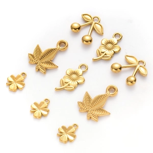 Macro shot of gold stainless steel pendants in cherry, leaf, flower, and clover shapes