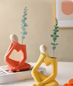 Detailed view of modern orange and yellow thinker-style ceramic vases for home decor
