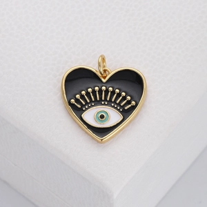 Detailed close-up of a heart-shaped evil eye pendant in gold and black enamel