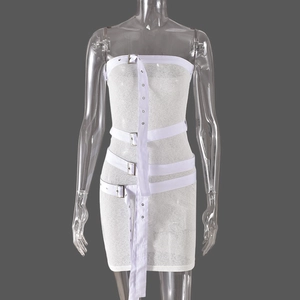 Detail of white tube dress featuring decorative straps and silver metal buckles