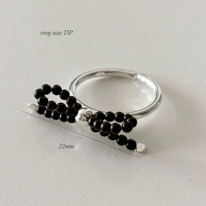 925 silver bow ring with black beads and 22mm span shown on a textured grey surface