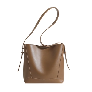 Classic brown leather bucket bag with adjustable strap in minimalist aesthetic style