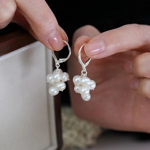 Close-up of handmade grape cluster earrings with white pearls and silver metal hooks