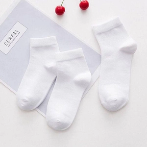 Flat lay view of three pairs of white cotton socks with cherry decor and artistic cards