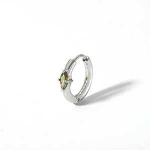 Macro shot of a silver hoop earring featuring a marquise-cut yellow zircon stone inlay