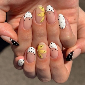 French almond press-on nails featuring yellow floral patterns and black polka dot designs