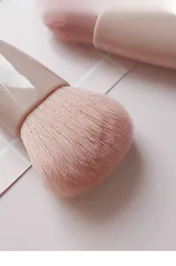 Macro shot of dense pink makeup brush bristles with soft texture and glossy handle